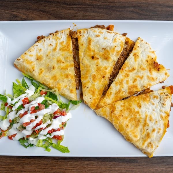 Habaneros Fresh Mexican Grill's quesadilla, cut into four triangles, served with a side salad.