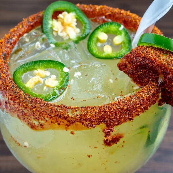 Spicy margarita with a chili-lime rim, fresh jalapeño slices, and a straw from Habaneros Fresh Mexican Grill.