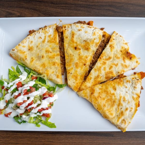 Four slices of Habaneros Fresh Mexican Grill quesadilla with ground beef, served with a side salad.